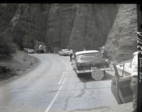 Collision between private car (Ford) towing U-Haul trailer and (Utah Parks Company) bus. NPS personnel regulating traffic at scene of collision.