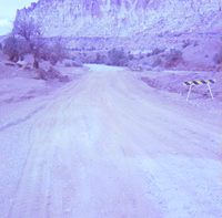 Dirt road with caution stand and Zion landscape in background.