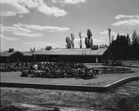 Man addressing visitors at the dedication of new Tribal and National Park Service Visitor Center and 50th anniversary at Pipe Spring National Monument. Fredonia High School Band seated in foreground.