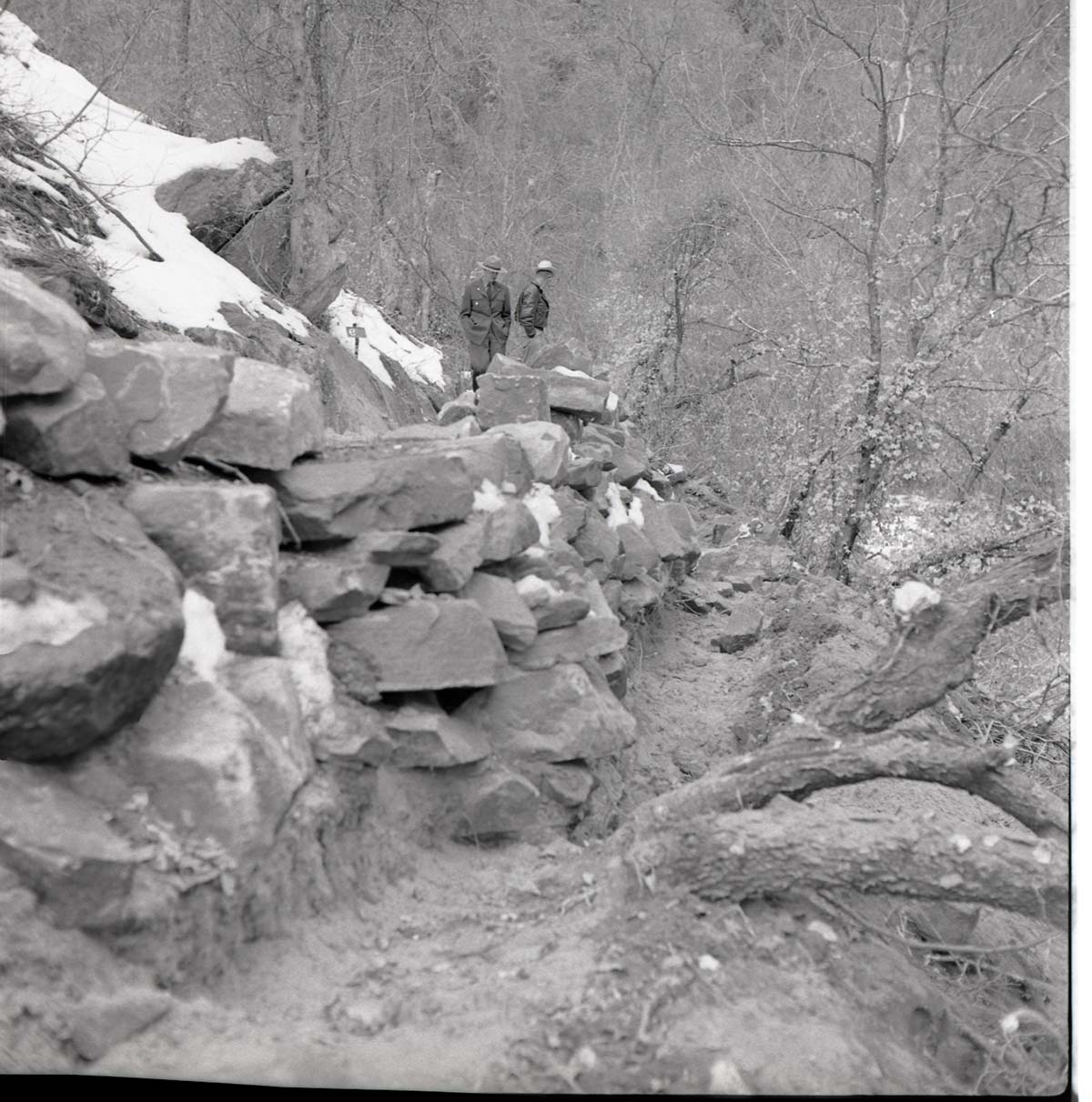 Two rangers viewing the damage on the trail and rock work on the Weeping Rock Trail.