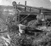 Stereograph of Zion Cableworks. William L. Crawford and children in photo. Caption 1: Views by W.L. Crawford, Springdale, Utah, Dixie Advocate Print, Virgin. Caption 2: Section of frame top of Zion Cable this cable is a half mile long and is used to convey lumber down the perpendicular precipice, on the top of which the mill is situated to the valley below.