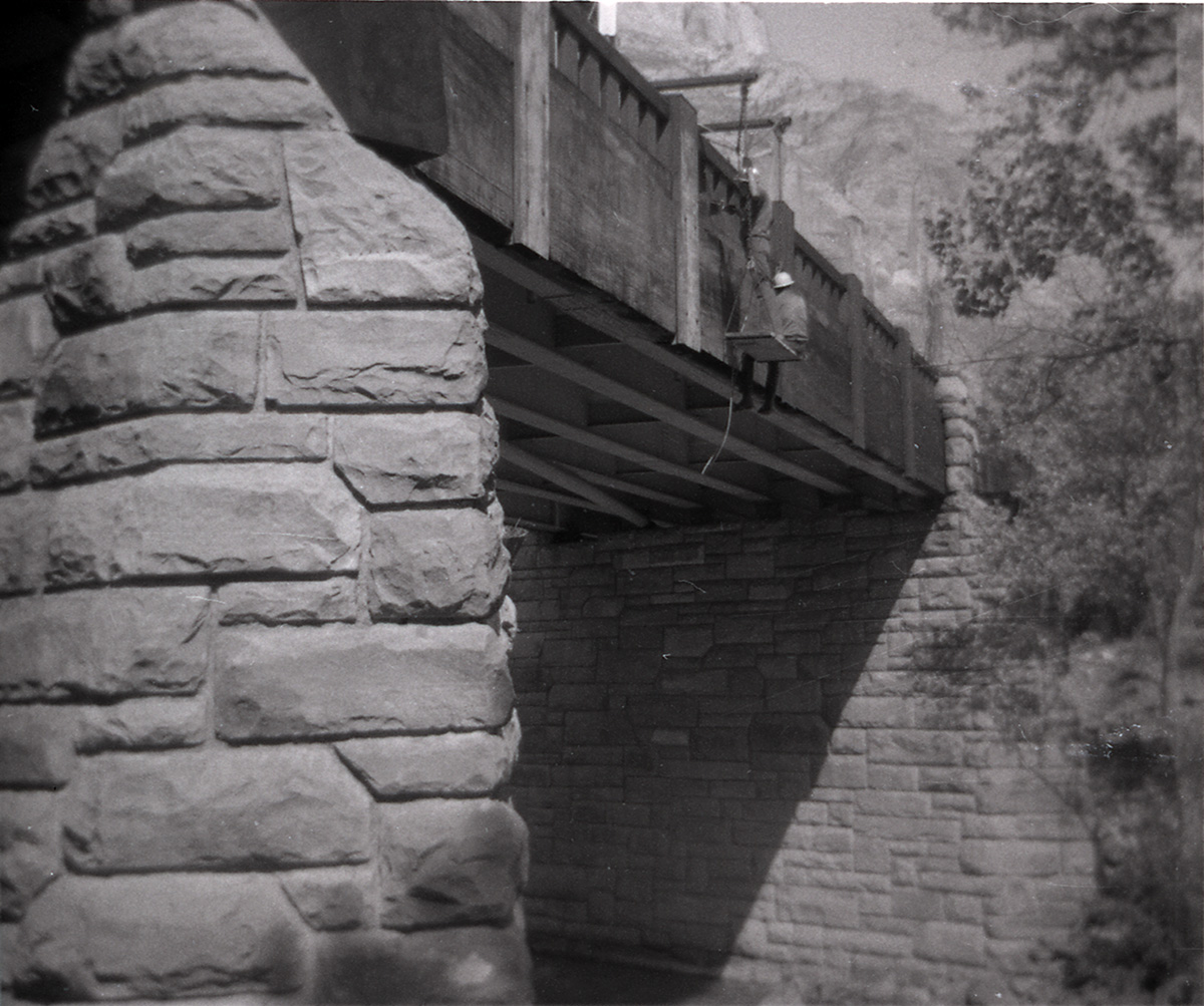 Men working on side of Canyon Junction vehicle bridge.