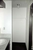 Sink and storage area in bathroom of barracks. [Image possibly for comparative housing study]