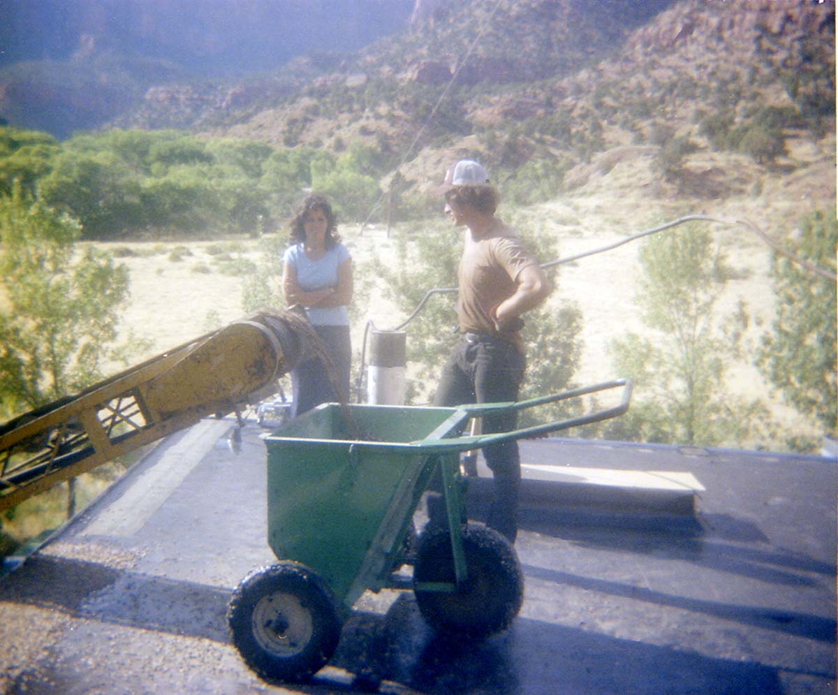Workers standing by as a roofing cart is filled with roofing material during headquarters/visitor center roofing project.