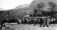 Visitors in formal attire watch choir performing during the First Easter church service at the new lecture circle, Camp Center, South Entrance.