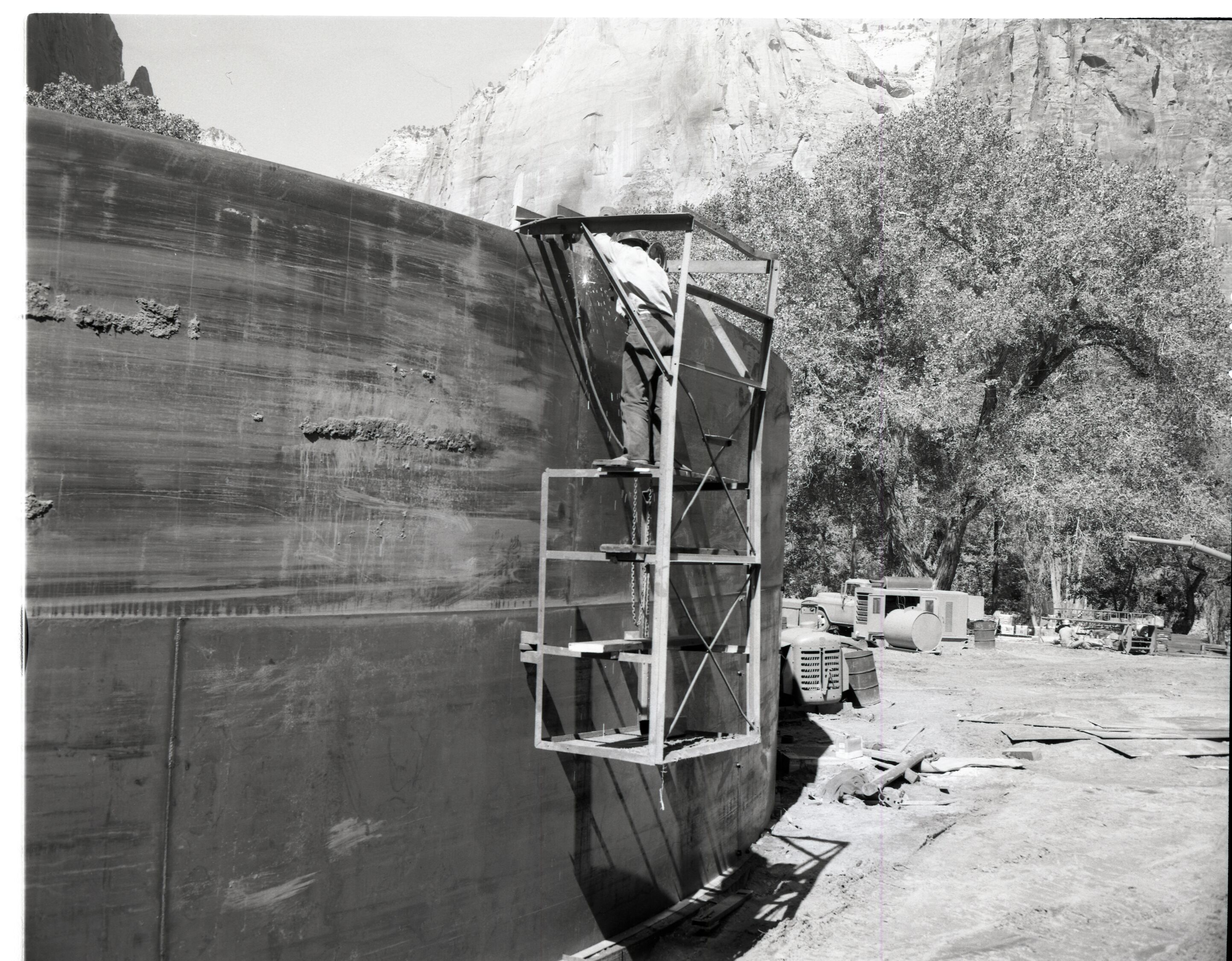 Construction of million gallon water tank at Birch Creek with workmen welding and cleaning inside walls.