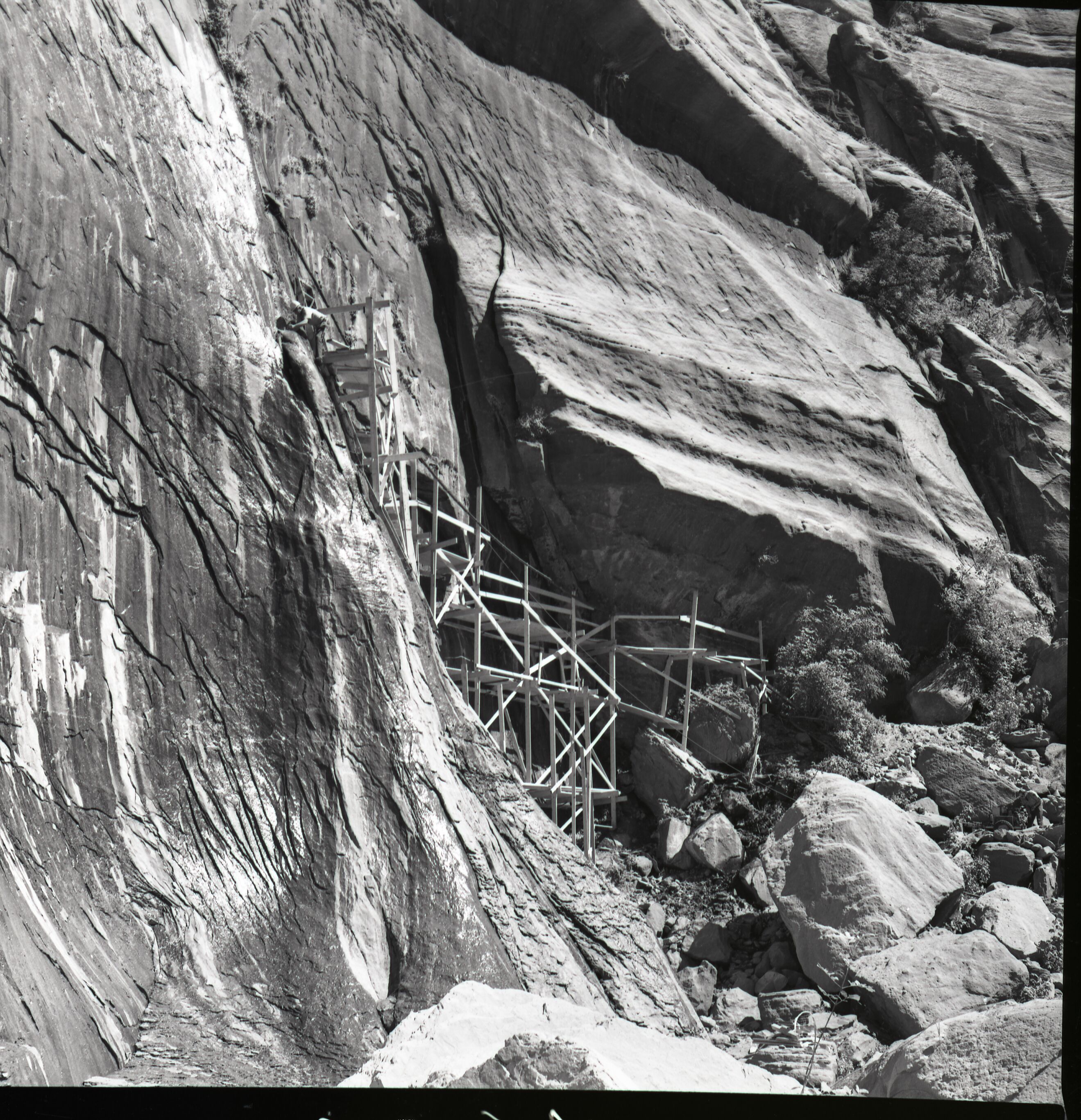 Crews upgrading water system at Temple of Sinawava - scaffolding up cliff face to spring.