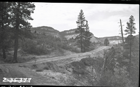 East Rim truck trail under construction. View of ponderosa pine trees and sage, with the white cliffs in the background.