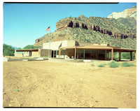 Exterior of old Mission 66 Visitor Center and Museum, with dirt lot surrounding building.