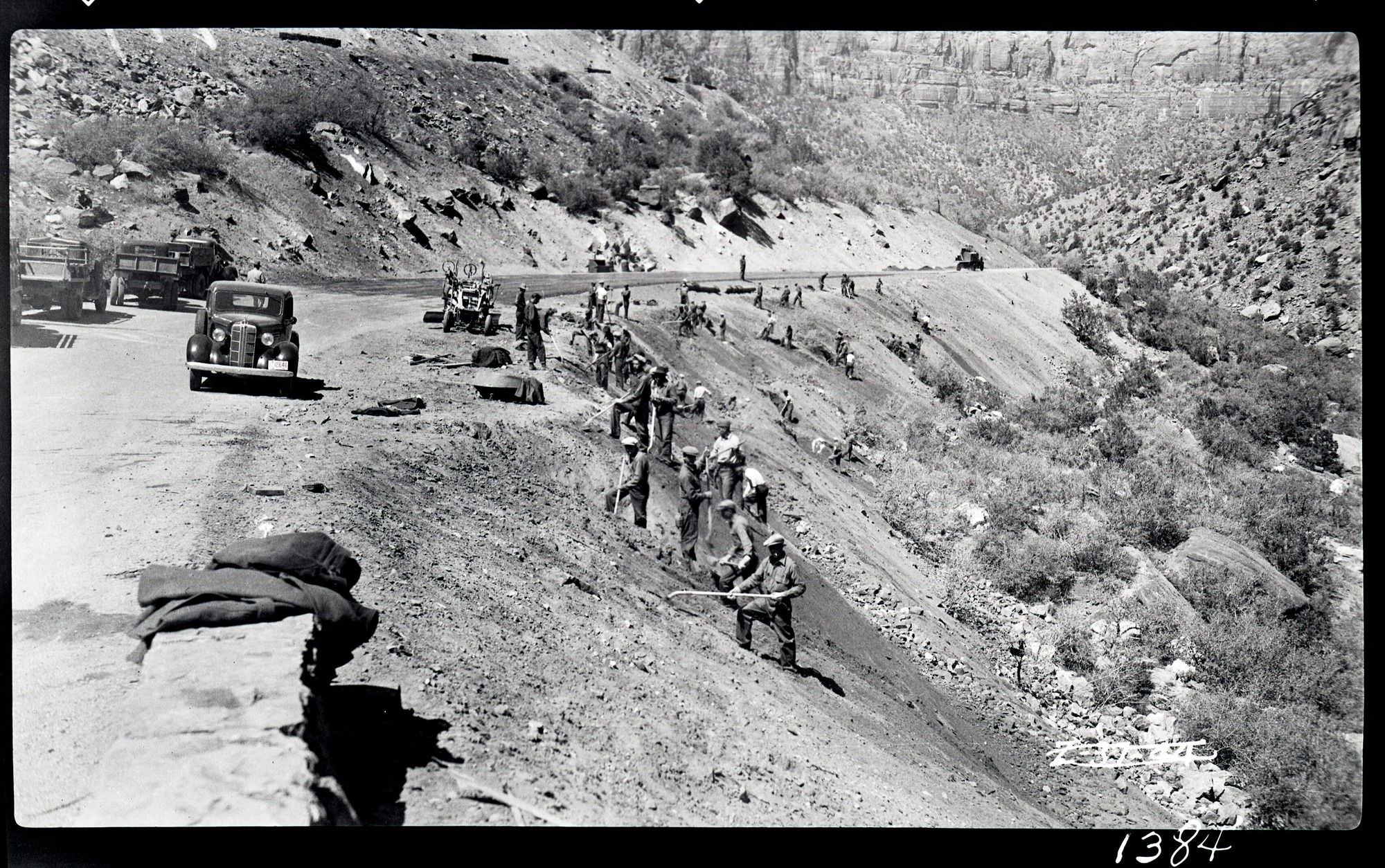 Civilian Conservation Corps (CCC) workers engaged in 'bank sloping' (hillside stabilization} along the Zion-Mt. Carmel highway below the tunnel.