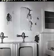 Damage to men's dorm at Zion Lodge. Damage to the wall above and to the side of the urinals.
