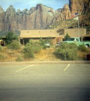 Vehicles parked in parking lot in front of the old Mission 66 Visitor Center and Museum.