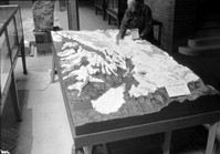 Painting priming coat of Zion relief model. Civilian Conservation Corps (CCC) worker Butler painting map.