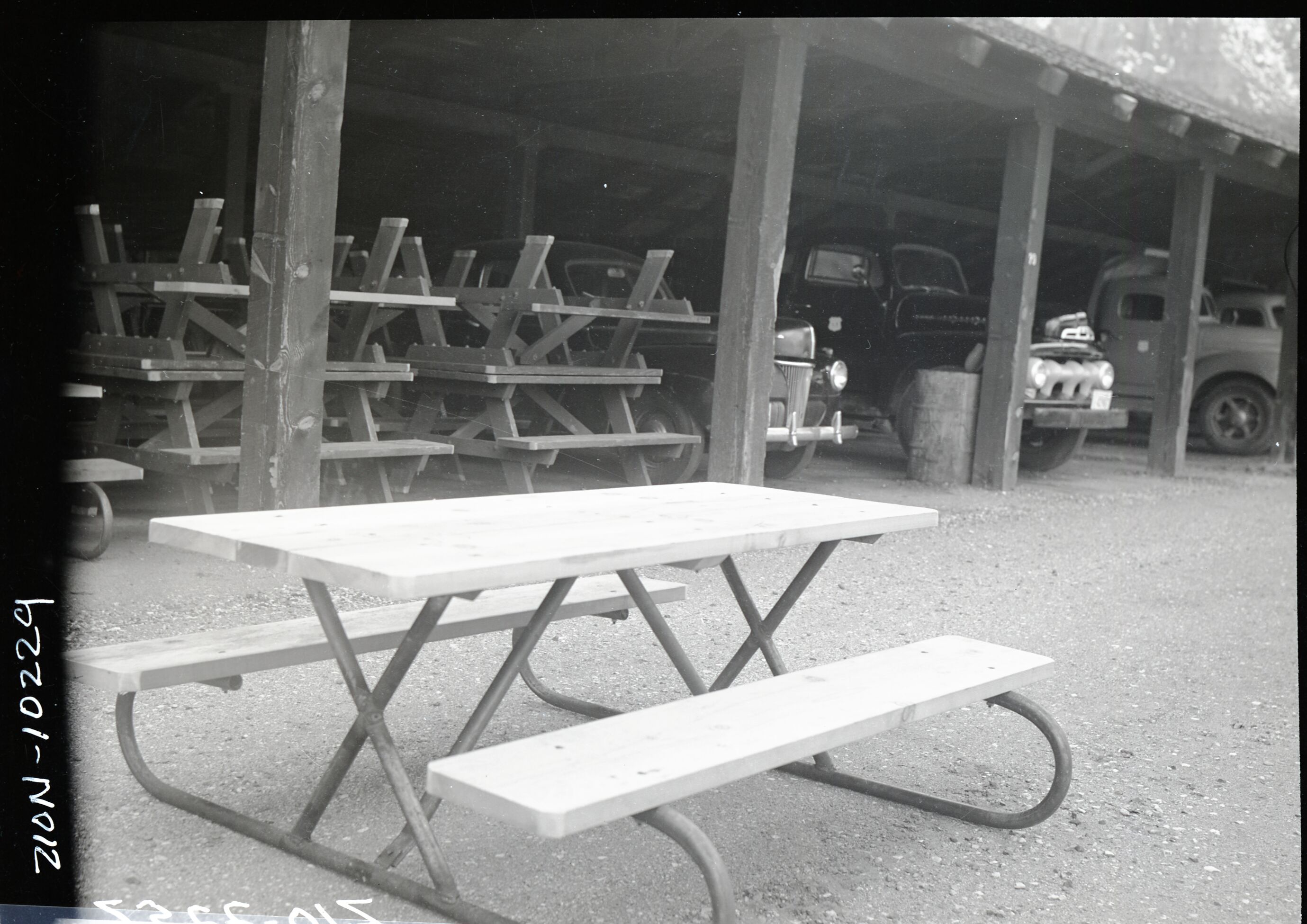 New type (iron and wood) campground picnic tables in utility area.