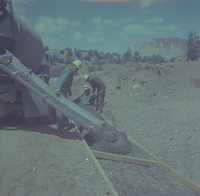 Men laying and leveling cement during road construction and repair.