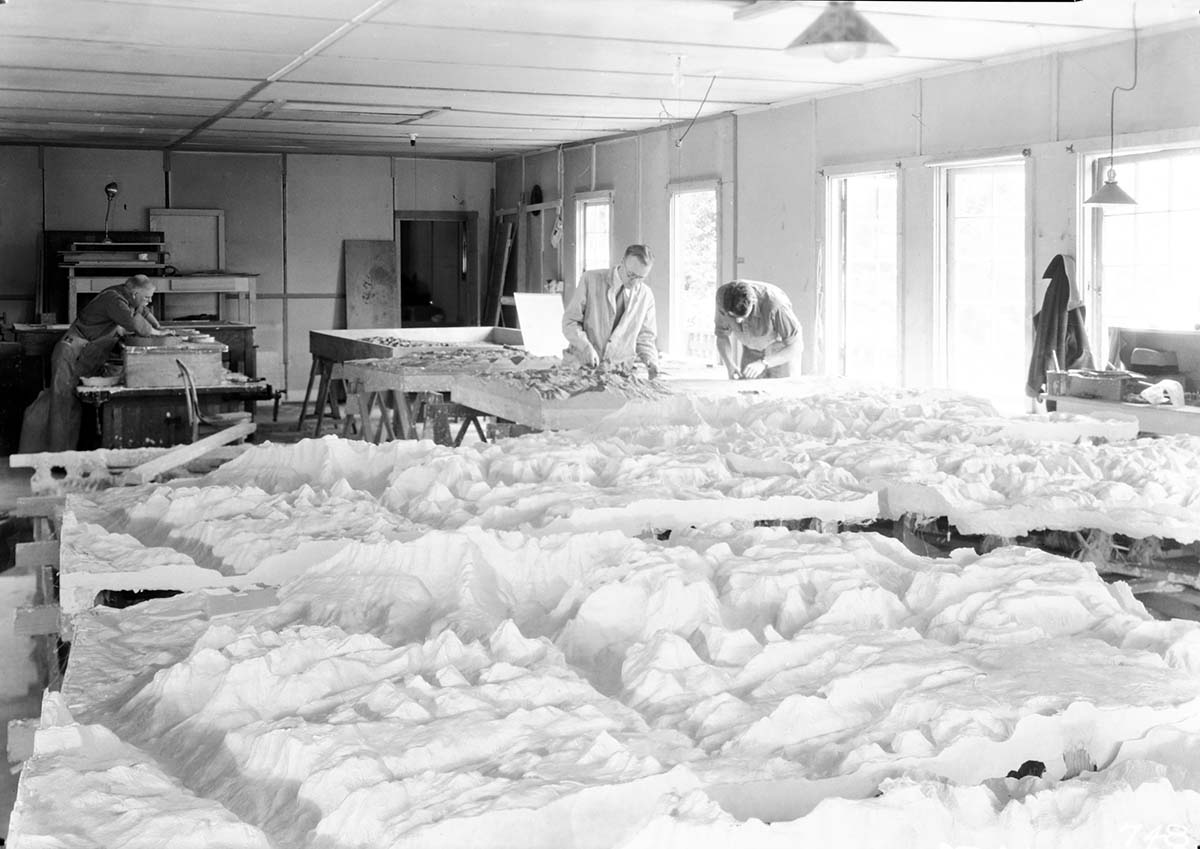 Workers at the Western Museum Laboratory (WML) fabricating the Zion relief map, with numerous plaster casts in the foreground.