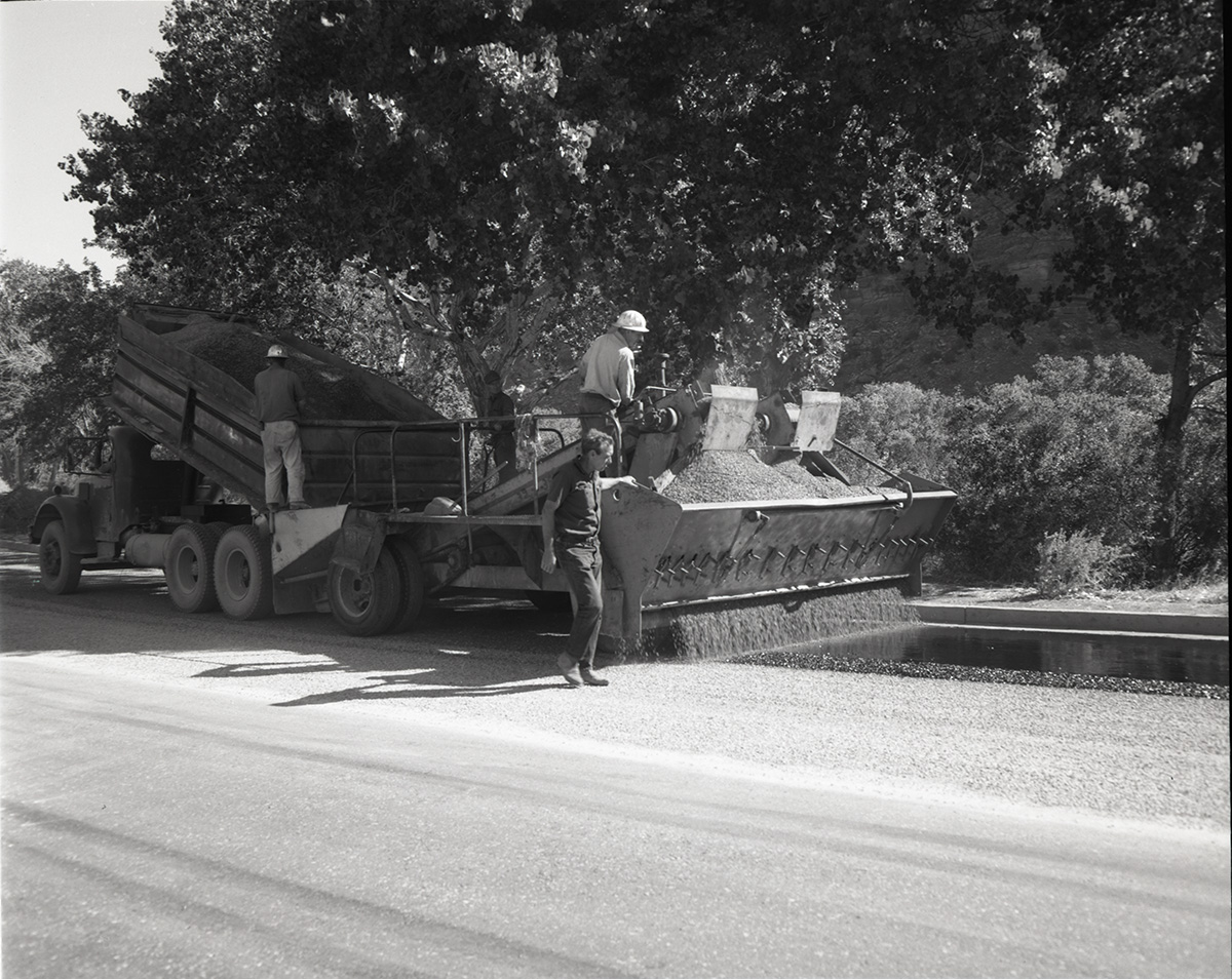 Men operating sealcoating machine while sealcoating parking area in Zion.