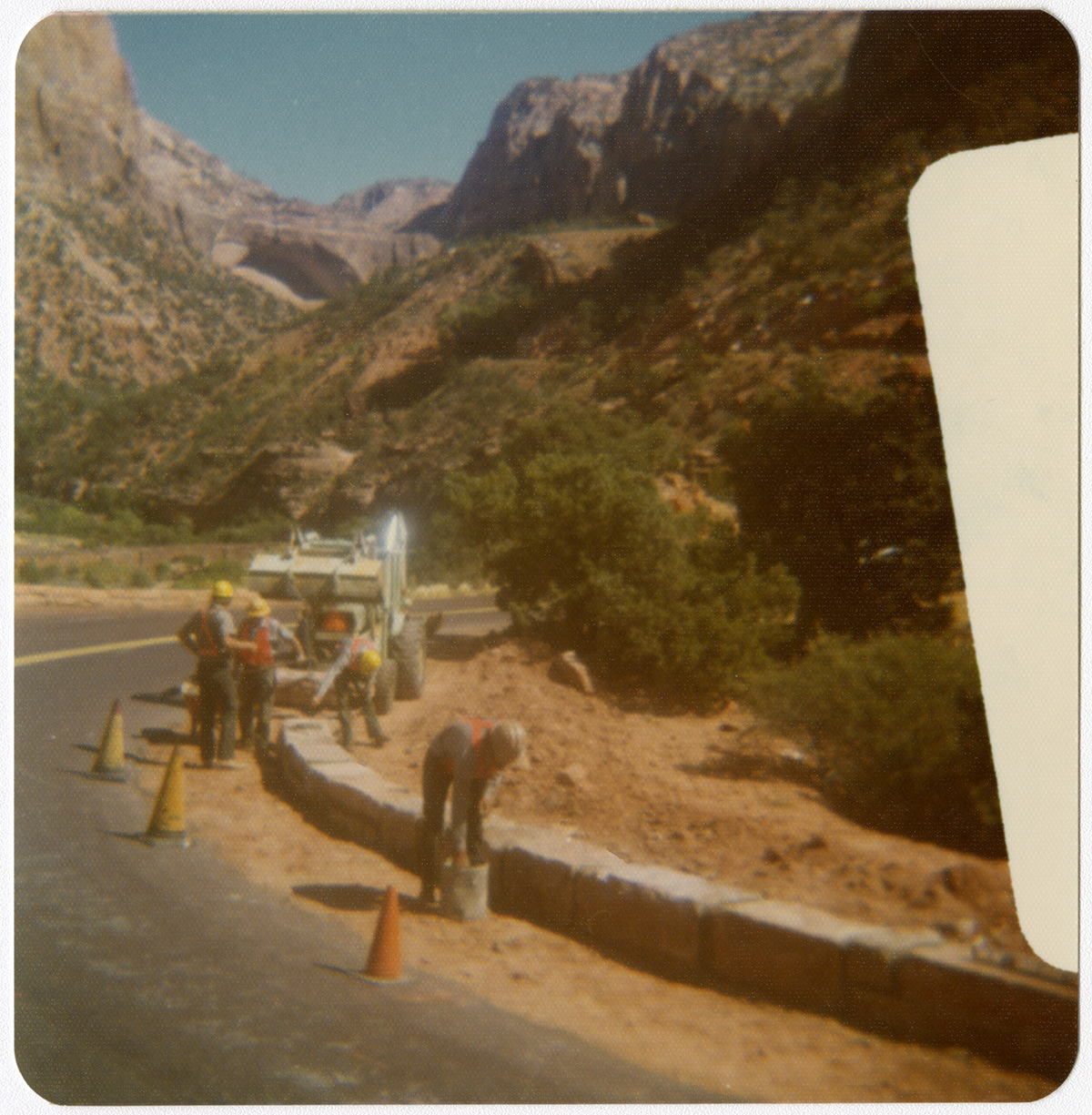 Men positioning traffic cones and preparing roads for chipsealing.