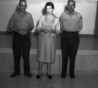 Sonehocker, Ruesch, and Heaton standing at the Mission 66 Visitor Center and Museum auditorium with their Service Award pins for 30 years of service.
