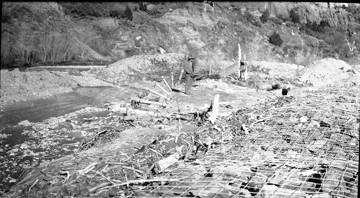 Basket dam #1 after a flood destroyed a footbridge leaving debris scattered along the banks.