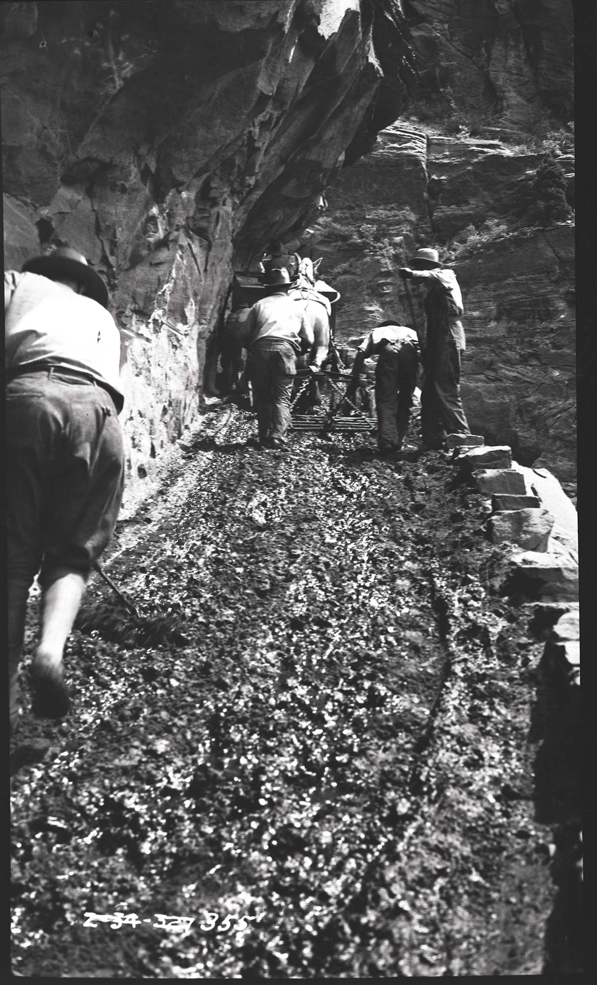 Construction of West Rim Trail with men and a horse.