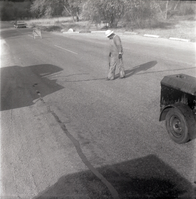 Man filling crack in road along the scenic canyon drive near the Grotto.