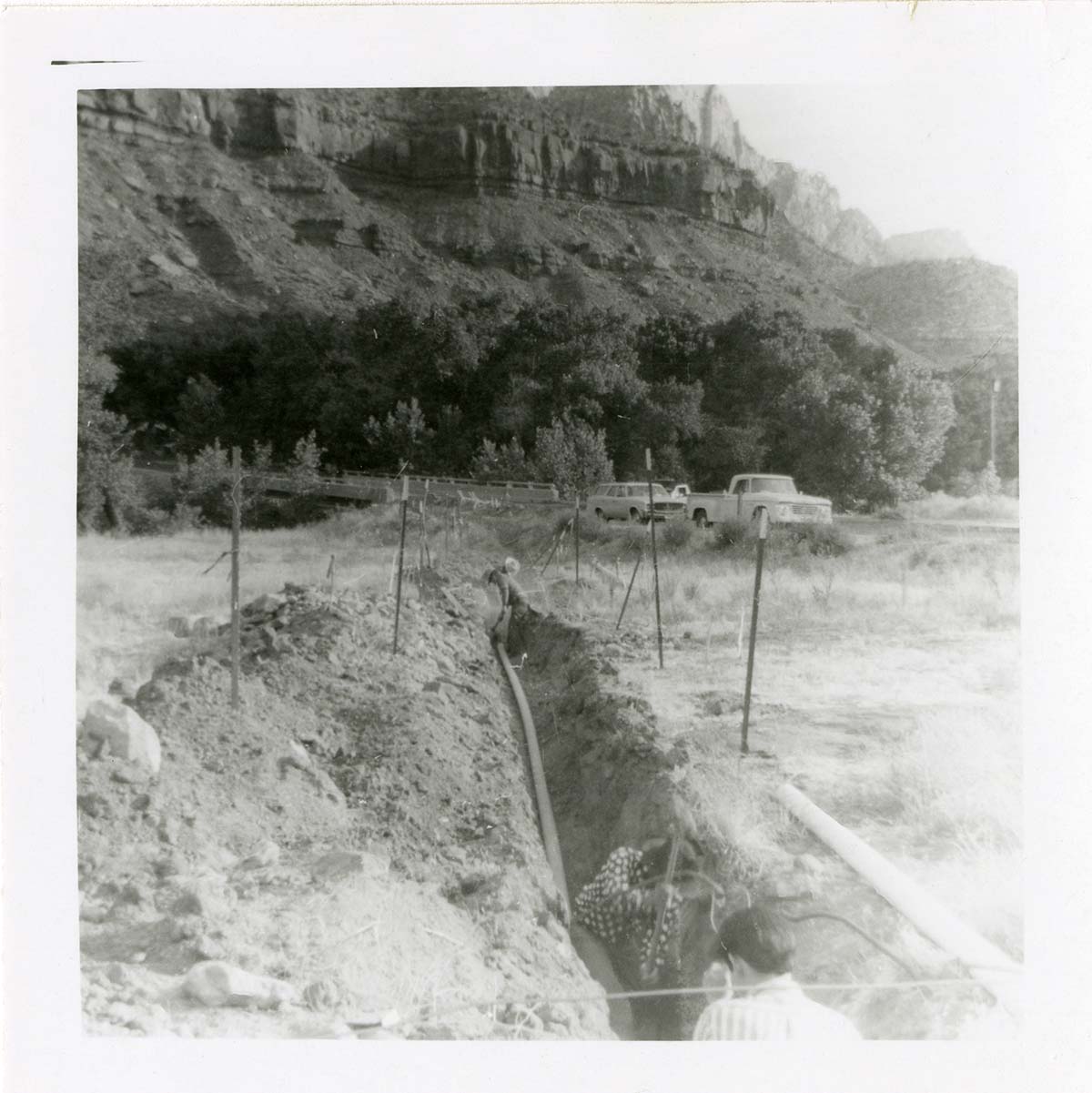 Workers digging ditch during the Watchman housing utility project.