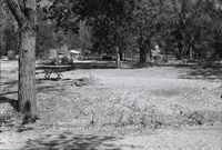 Campsites with picnic tables and grills, tent set up in background of South Campground.