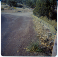 Section of road in need of repairs marked by yellow and black striped construction signs.