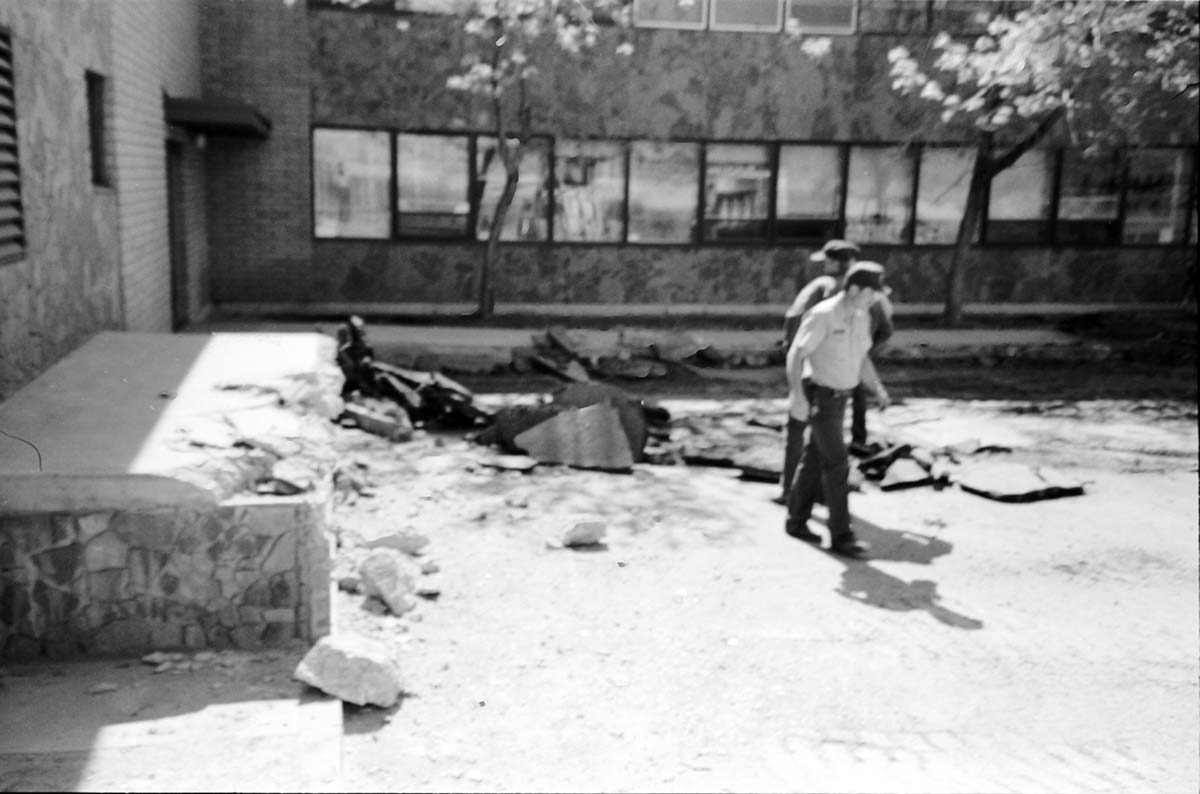 Workers examining cracked cement during the construction of headquarters addition.