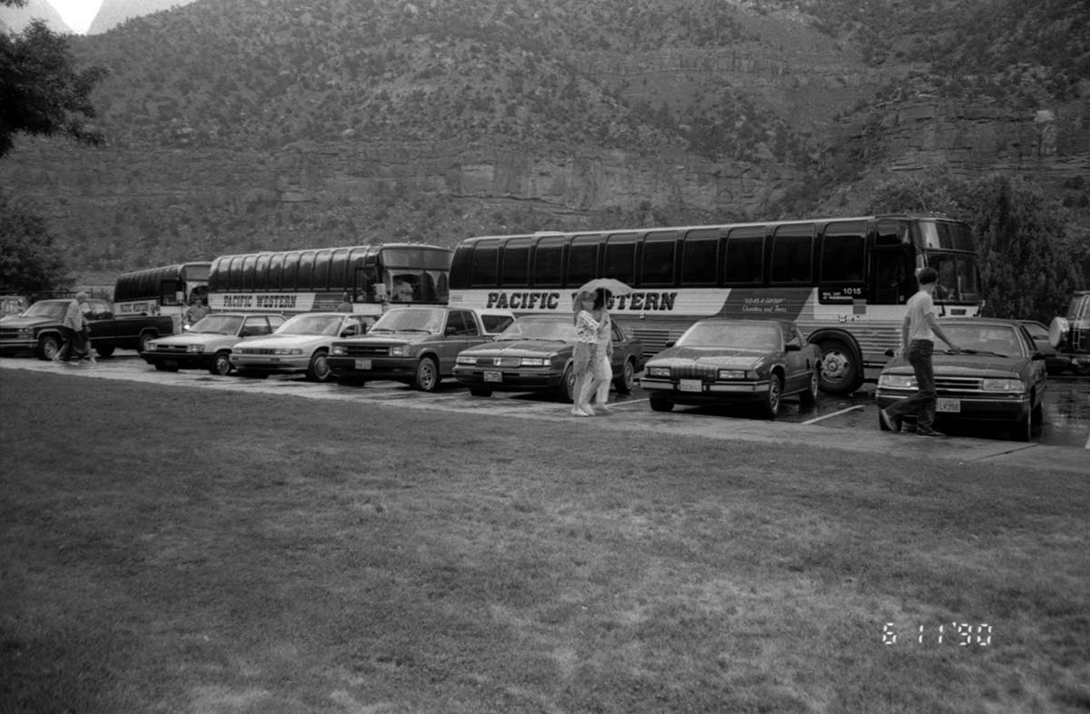 Buses and cars parked in the lot in front the of the headquarters building.