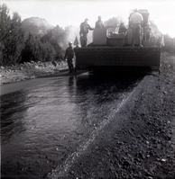 Men operating construction vehicles during chipsealing of Kolob Canyon Road.