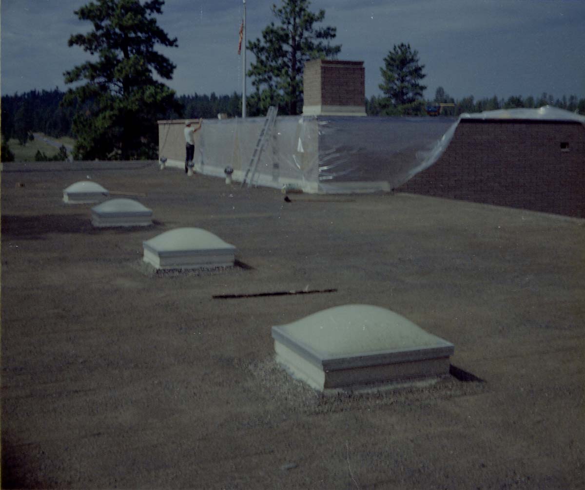 Man putting up plastic sheeting during reroofing project. Bryce Canyon National Park.