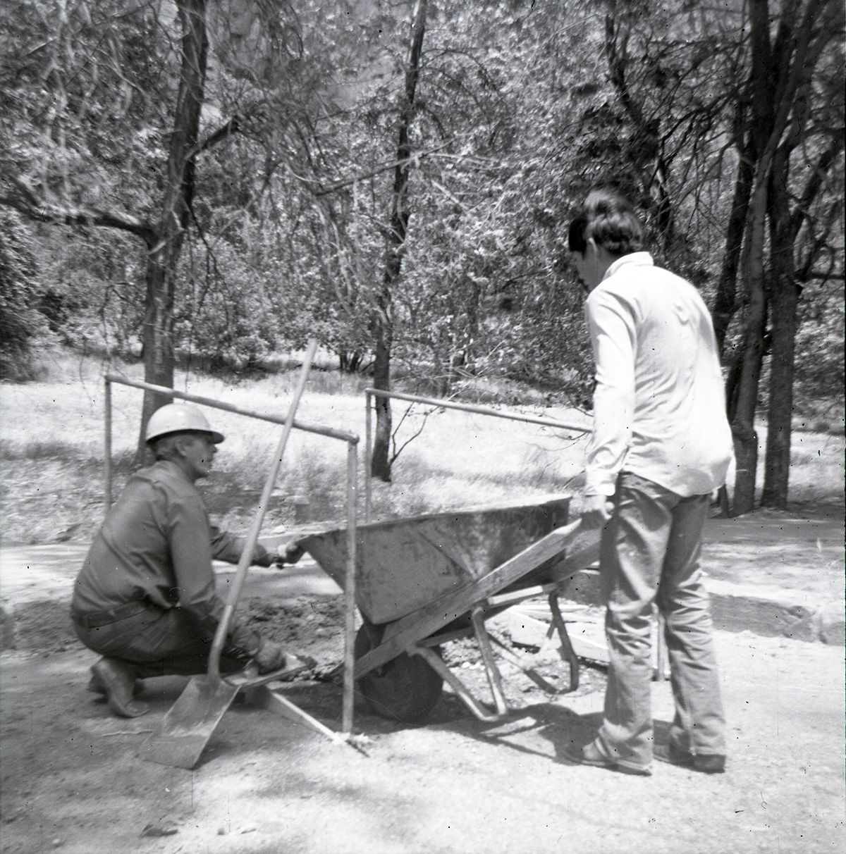 Men using wheelbarrow to work on Great White Throne parking area.