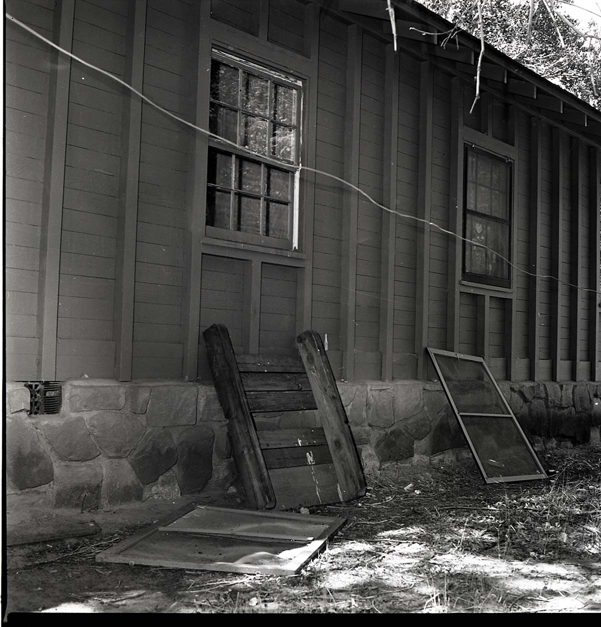 Damage to the men's dorm at Zion Lodge. Window, screen, and furniture outside of dorm.