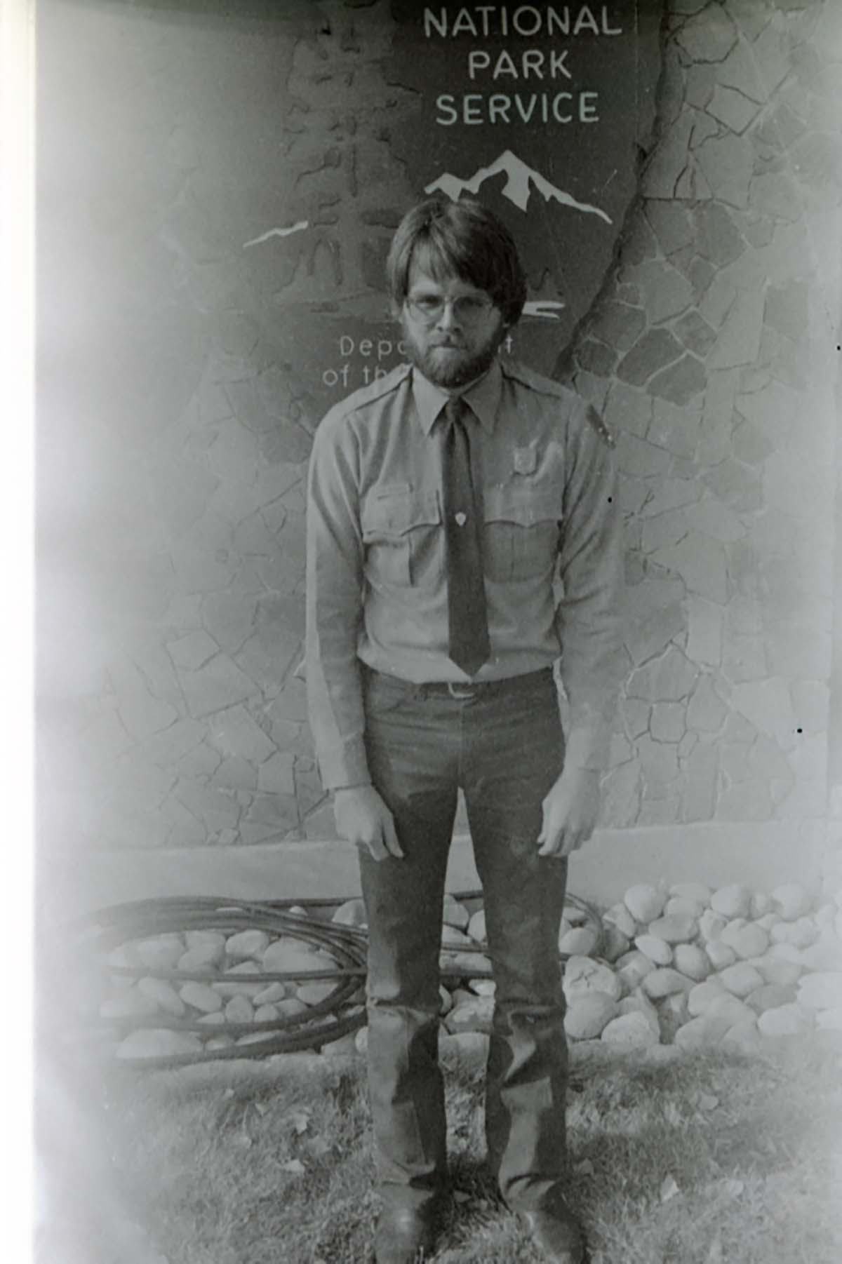 Man with beard hunching his shoulders.