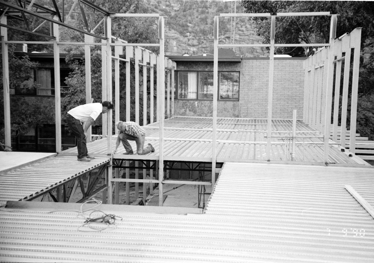 Men examining the building materials during construction of headquarters addition.