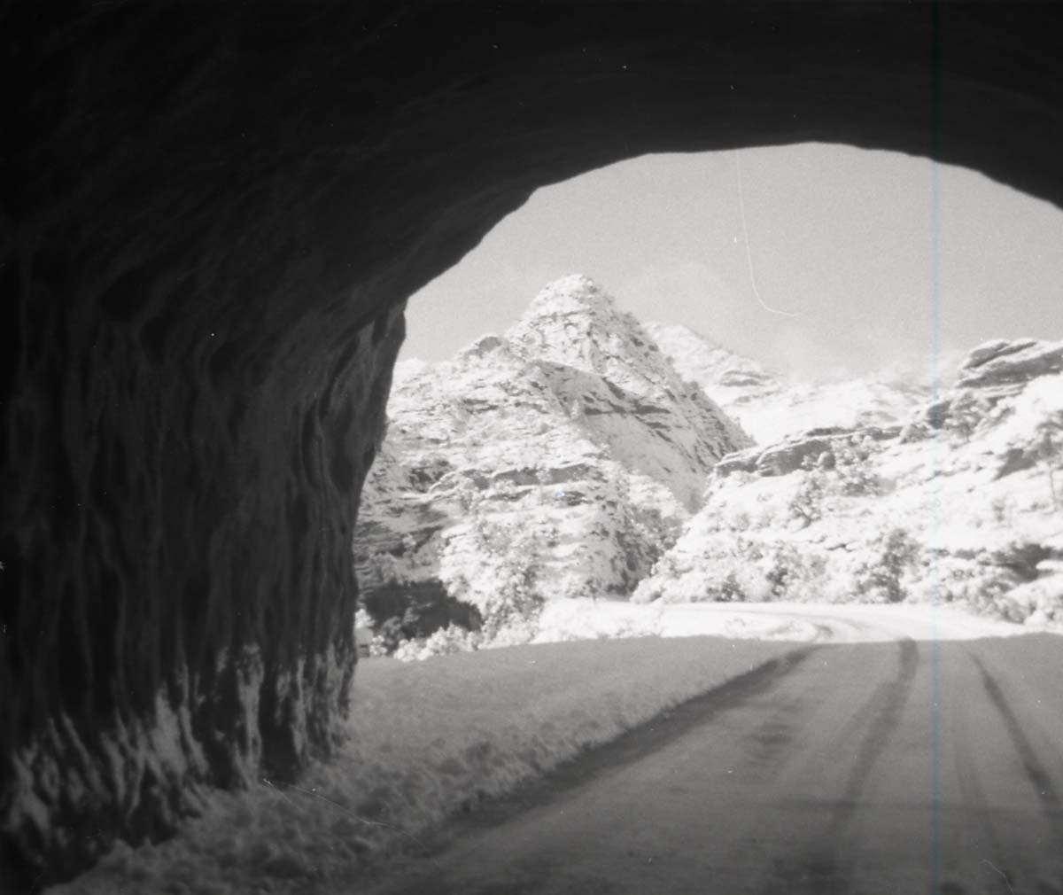 BW photo of snowy road through small tunnel on east side of park.