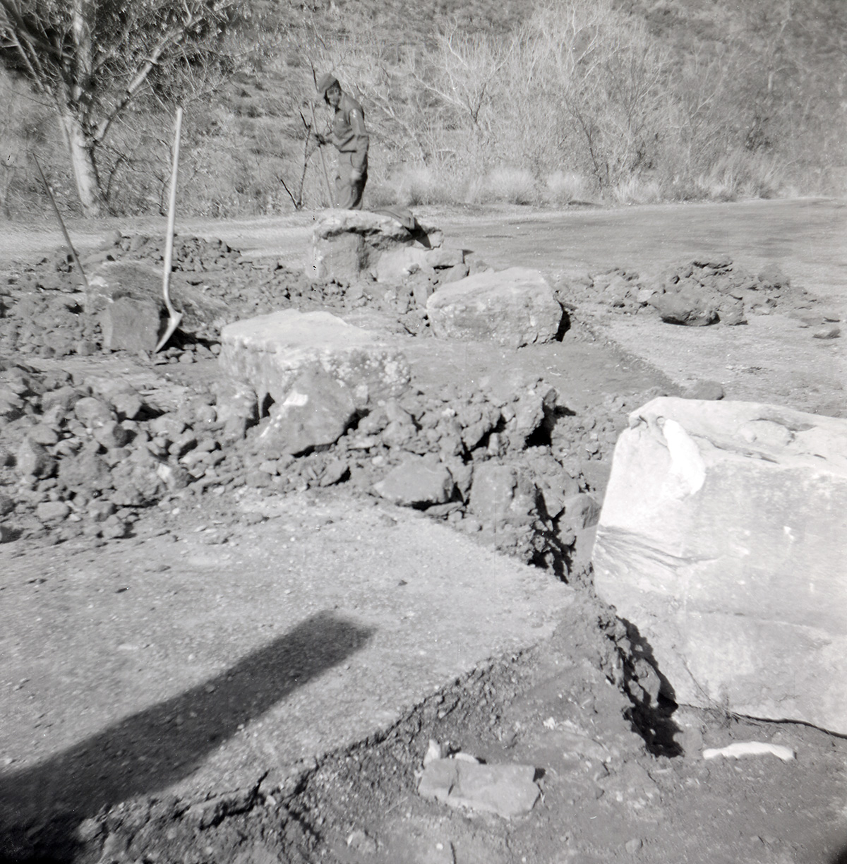 Man clearing the path of rocks and boulders during construction of the Great White Throne parking area.