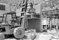 Man in a bucket lift working on the construction of headquarters addition.