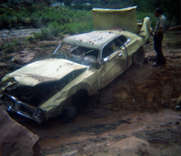 Color photos of park personnel removing a car from the flood waters of the 1975 flood.