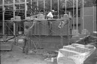 Workers building brick wall during the construction of the headquarters addition.