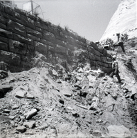 Men observing the repairs of retaining wall along East Rim road.
