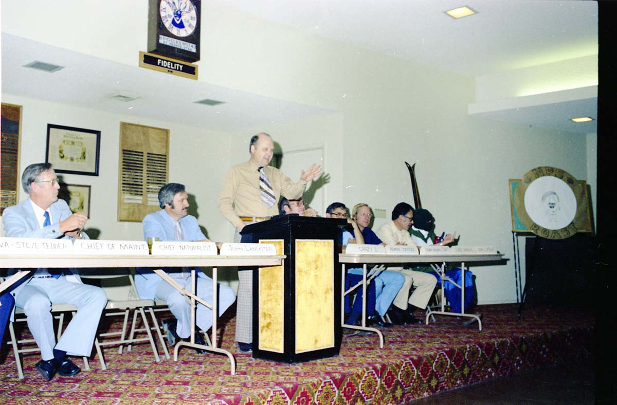 Color Photos of John Lancaster's farewell party at Elks Club in St. George, Utah. Speakers at roast in front of room: Pipe Spring National Monument Superintendent, TWA Steve Tedder, Chief of Maintenance, Chief Naturalist, John Lancaster, Crazy D, Administrative Officer, Cedar Breaks National Monument Superintendent, Chief Ranger, Unknown Skier.
