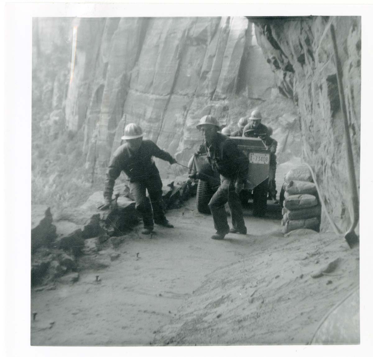 Workers operating construction equipment during the West Rim trail half tunnel maintenance/stabilization.
