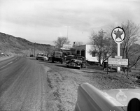 Roadside signs near Zion. 'A collection of cars, trucks and tractors in the parking area in front of the 101 Ranch service station. Limited space between station and Highway 15 [State Route 15, now State Route 9].'