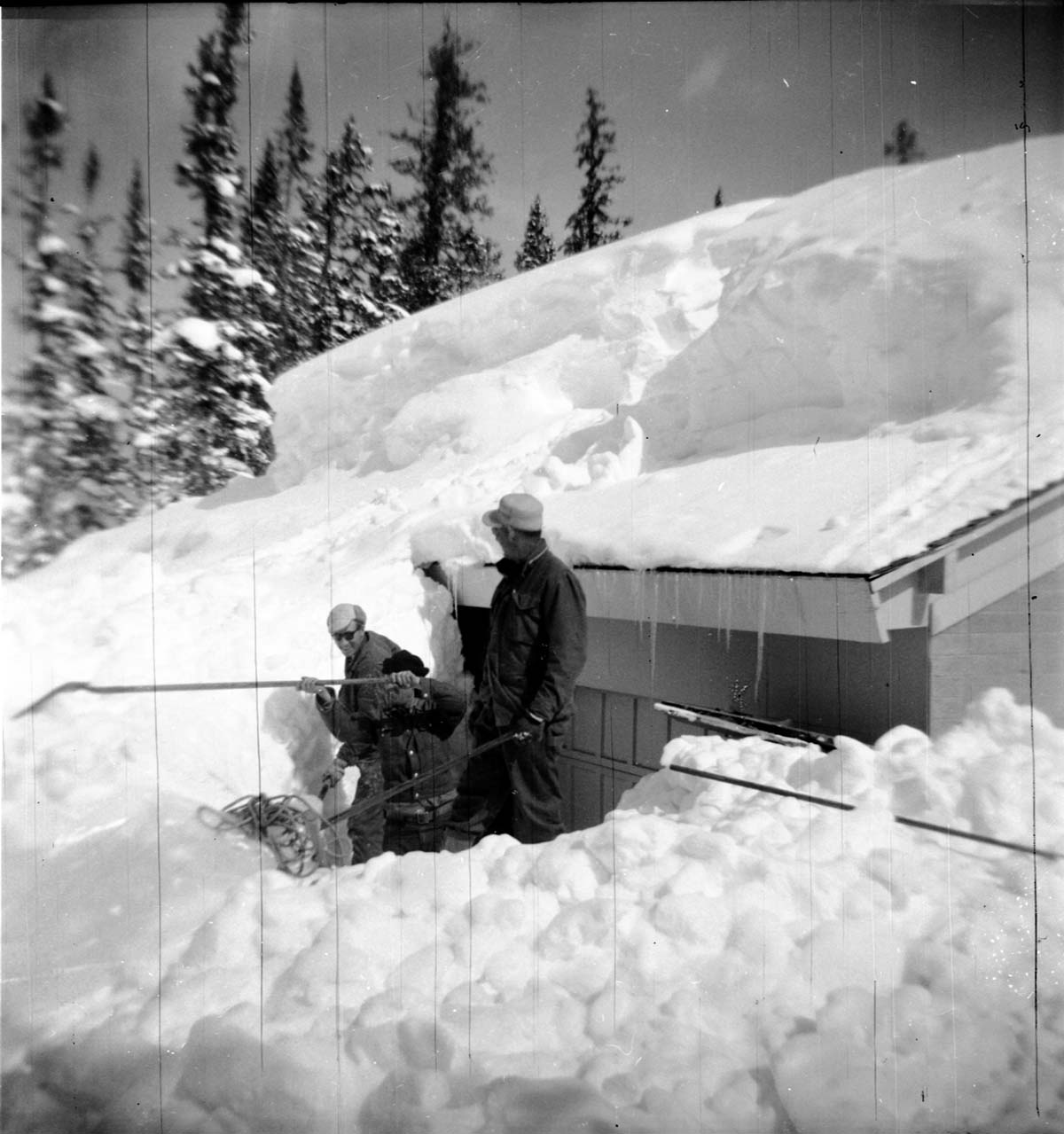 BW Photos showing rangers digging out the visitor center from snowdrift.