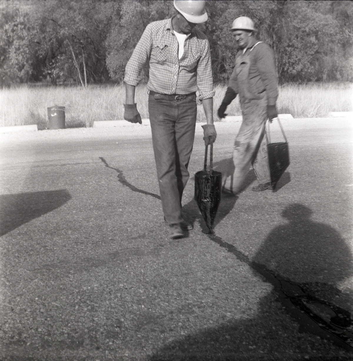 Men filling cracks in the road along the scenic canyon drive near the Grotto.