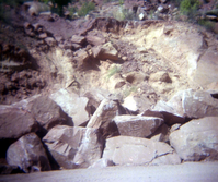 Color Photo of a rock slide along road.