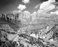 The Sentinel and the Streaked Wall from Pine Creek Canyon. Zion-Mt. Carmel Highway switchbacks in foreground.